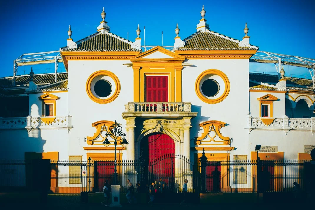 les arenes de seville jaune et rouge sous le soleil, voyage en espagne