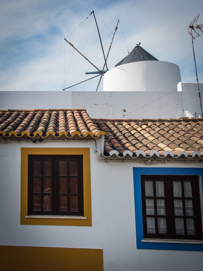 fenêtre jaune et bleu sur fond de moulin a vent a odeceixe au portugal voyage en algarve