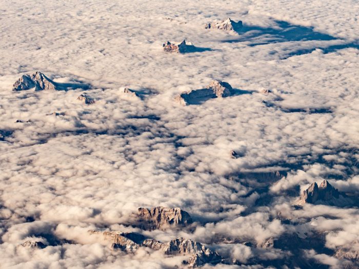 une mer de nuage vue du ciel avec des sommets des alpes qui surgissent dans le soleil